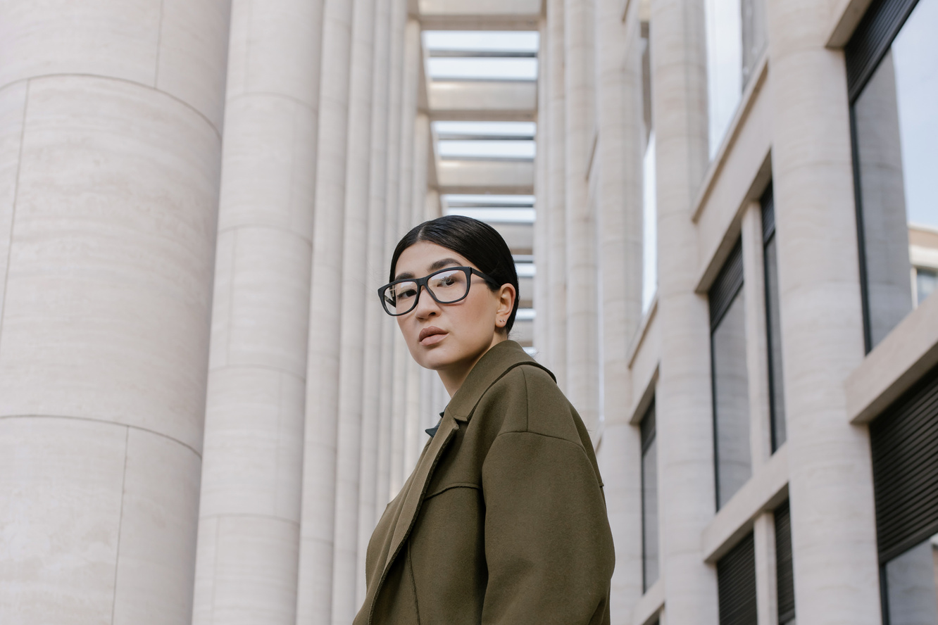 Woman Wearing Coat Beside a White Building